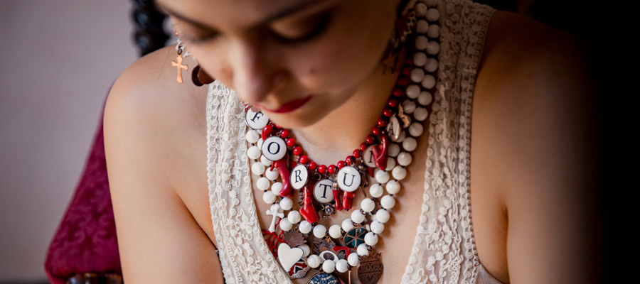 Amulets, lucky charms, talismans run on the pearls in red coral bamboo. All the symbology, from little horns to four-leaf clovers to wish you all the best