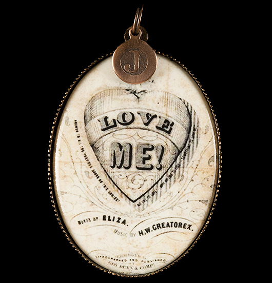 medallion in porcelain with an image of a sacred heart and written 